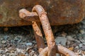 A thick rusty chain lies on the ground