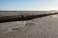 A thick rusty pipeline on a sandy beach near the ocean at a beach replenishment site Royalty Free Stock Photo