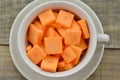 Thick slices carrots with cup on wooden table, rustic