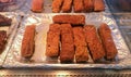 Thick slices of crispy roasted pork belly for sale on display in thermal counter in deli department of supermarket Royalty Free Stock Photo