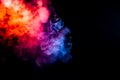 Thick smoke exhaled from a vape, highlighted by a blue-violet orange color like a flame an explosion against a black background, Royalty Free Stock Photo