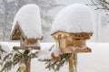Thick snow falling on roof of wooden bird feeder during winter i