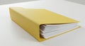 A thick stack of white paper sheets is partially enclosed in a folded yellow folder. The Royalty Free Stock Photo