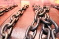 Thick, strong, iron, steel old chains against the background of an ancient wooden Royalty Free Stock Photo