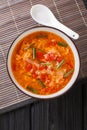 Thick tomato egg drops soup or Chinese flower soup close-up in a bowl. Vertical top view