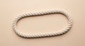 A thick, white rope with a twisted texture is arranged in an oval shape against a beige background. Royalty Free Stock Photo