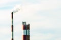 Thick white smoke coming out of a large pipe of an industrial facility or factory. A smoking chimney against a blue sky. Royalty Free Stock Photo