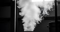Thick white steam billows from a pipe in an industrial setting, illuminated by light Royalty Free Stock Photo