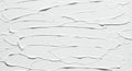 Thick white textured paint is spread across the surface in smooth, overlapping