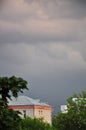 thickening leaden thunderclouds over the brick houses