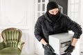 Thief with black balaclava stealing modern Electronic safe box. The burglar commits a crime in Luxury apartment with