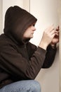 Thief in black hoodie breaking in property with plastic lockpick homemade blades Royalty Free Stock Photo