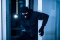 Thief breaking into apartment to steal, using flashlight Royalty Free Stock Photo