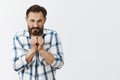 Thief caught by police, feeling angry and displeased. Portrait of mad adult male with beard and dark hair, holding