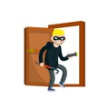 Thief with crowbar. Masked robber in black clothes broke down door of house