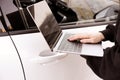 Thief hacking car system with laptop near vehicle, closeup Royalty Free Stock Photo