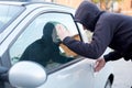 Thief looking inside a car window ready to steal