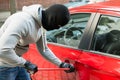 Thief With Mask Using Crowbar To Open Car`s Door Royalty Free Stock Photo