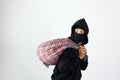 Thief with Sarung Bag Looking at Side, Feeling Satisfied After Robbery Royalty Free Stock Photo