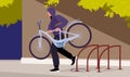 Thief stealing bicycle from rack in public city area, bike theft on street. Man carrying stolen personal transport and Royalty Free Stock Photo