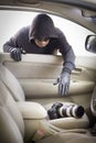 Thief stealing camera from car Royalty Free Stock Photo