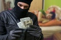 Thief is stealing money from money when is man sleeping Royalty Free Stock Photo