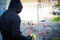 Thief stealing a parked bike in city street Royalty Free Stock Photo