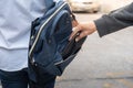 Thief stealing the wallet or mobile phone from behind young caucasian woman bag on street, thief, crime, robber and steal concept