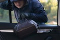 The thief steals a bag from the car through the open glass Royalty Free Stock Photo