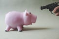 Pink piggy bank and hand with gun Royalty Free Stock Photo