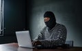 Thief use computer for theft. Hacker stealing data from a laptop concept for network and computer crime Royalty Free Stock Photo