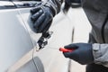 The thief uses a screwdriver Stealing a car at the door handle. The vehicle insurance concept Royalty Free Stock Photo