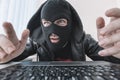 Thieves hold credit cards using laptop computer for password hacking activities. Cyber crime concepts. a male thief