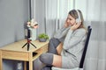 Thigh high socks on woman who watches virtual classes on smartphone on tripod