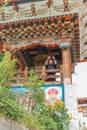 Thimphu, Bhutan - September 15, 2016: Low angle view of a happy monk in front of the prayer wheel in Simtokha Dzong, Thimphu