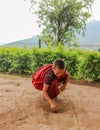 Thimphu, Bhutan - September 15, 2016: Young Bhutanase monk putting coins on the soil in a monastery in Bhutan