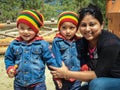 A twin Bhutanese children in colorful wear posing for a photograph with a lady