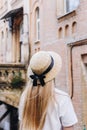 A thin blonde girl with long hair in a white dress stands with her back to the camera and looks into the distance in a wide- Royalty Free Stock Photo