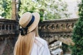 A thin blonde girl with long hair in a white dress stands with her back to the camera and looks into the distance in a wide- Royalty Free Stock Photo