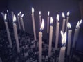 Thin candles burning away in a church