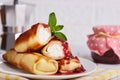 Thin crepe pancake rolls stuffed with cottage cheese, served with raspberry jam.