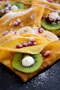 Thin Crepes with melted chocolate, sesame seeds, pomegranate and almonds Royalty Free Stock Photo