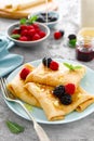 Thin crepes with fresh berries and lemon zest. Pancakes with raspberry and blackberry