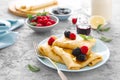 Thin crepes with fresh berries and lemon zest. Pancakes with raspberry and blackberry