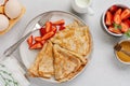 Thin crepes pancakes with cream cheese, fresh strawberry and ingredients for making breakfast. Top view Royalty Free Stock Photo