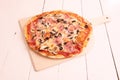 Thin crust pizza with red onion, ham, mushrooms, slices of black olives, mozzarella cheese with tomato Royalty Free Stock Photo