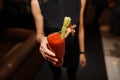 Female in the black shirt holding a glass of alcoholic cocktail Bloody Mary Royalty Free Stock Photo