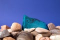 Thin flat piece of blue mint handmade soap lying on a pile of pebble Royalty Free Stock Photo