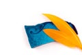 Thin flat piece of blue mint handmade soap and two orange feathers