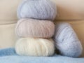 Thin fluffy skeins of wool for knitting a pale pink, blue and be